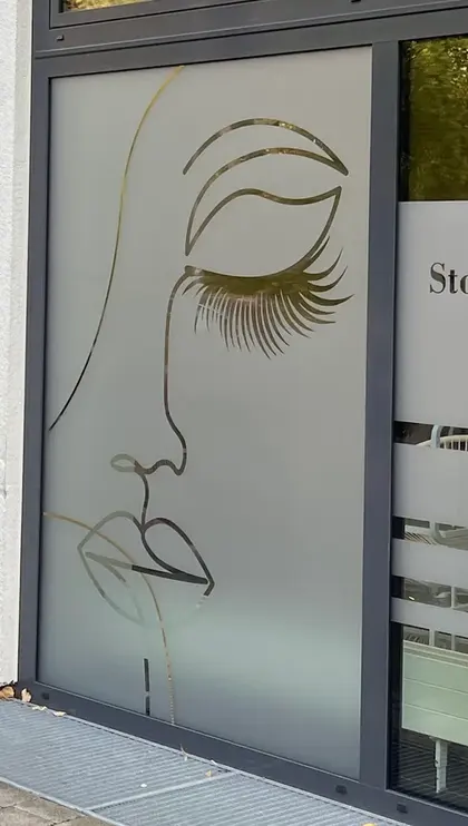 Goldenes Linien-Gesicht mit langen Wimpern als Fensterbild