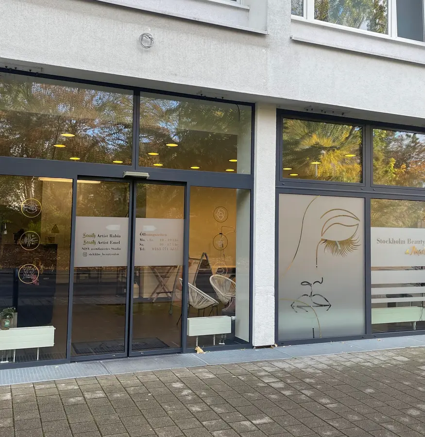 Eingang des Studios mit Glasschiebetür und Fensterbildern